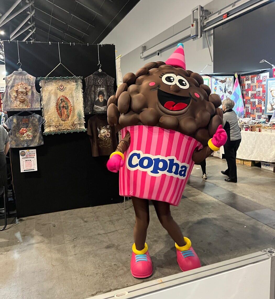 Coral Crackle, Copha's chocolate crackle mascot, on the fair floor at Cake! Alley