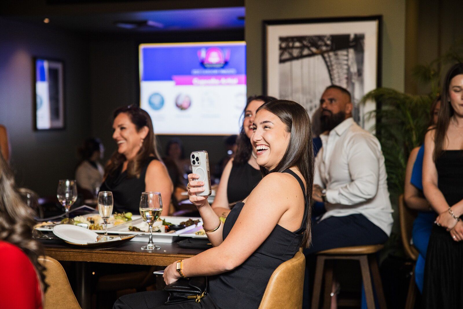 Guests seated at a dinner table laughing during the 2025 awards presentation