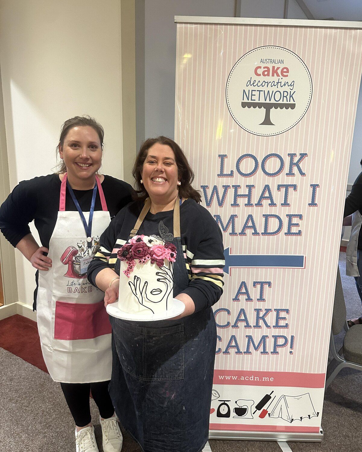 Two members with a finished cake at Cake Camp