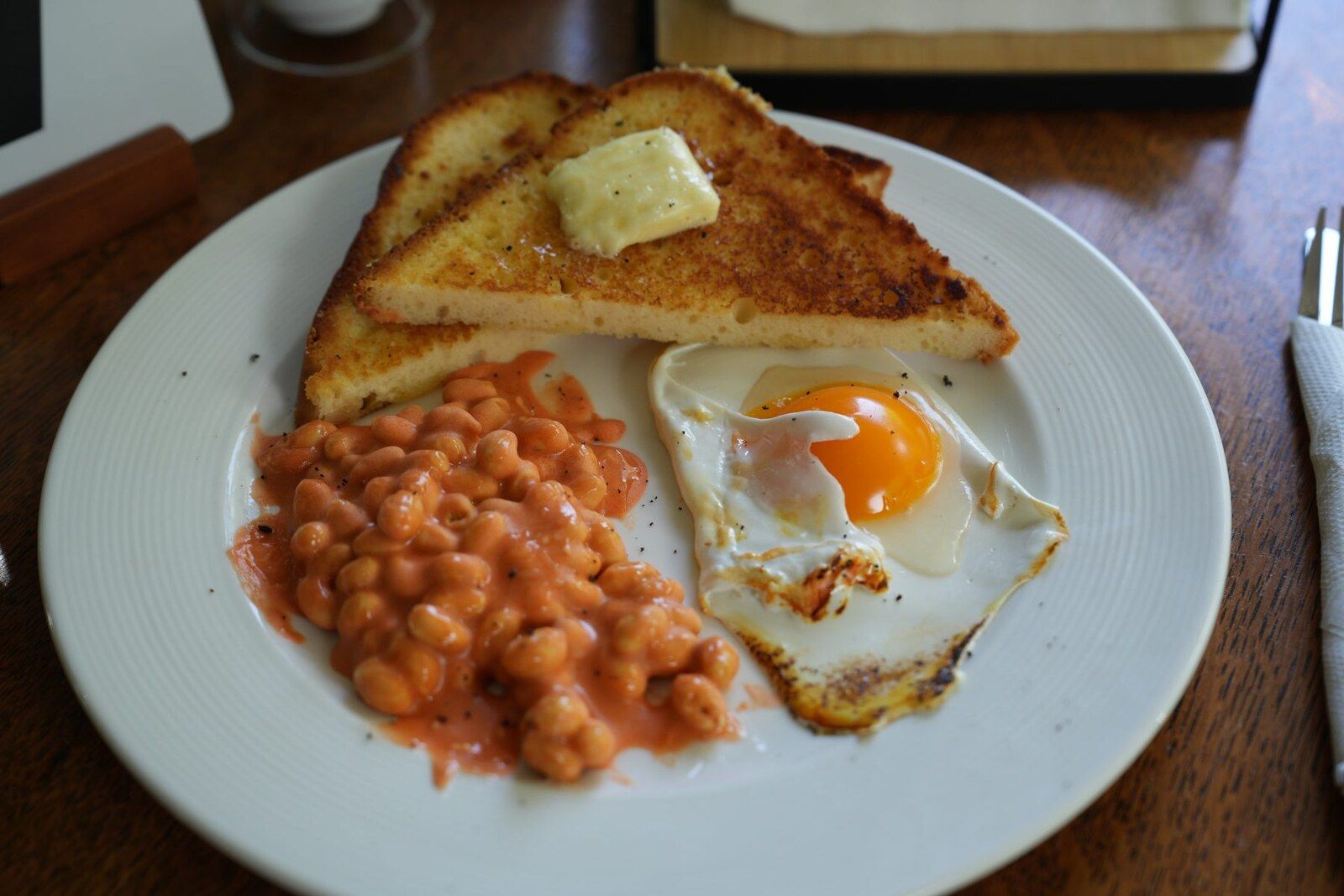 A hyperrealistic cake made to look like eggs and beans on toast